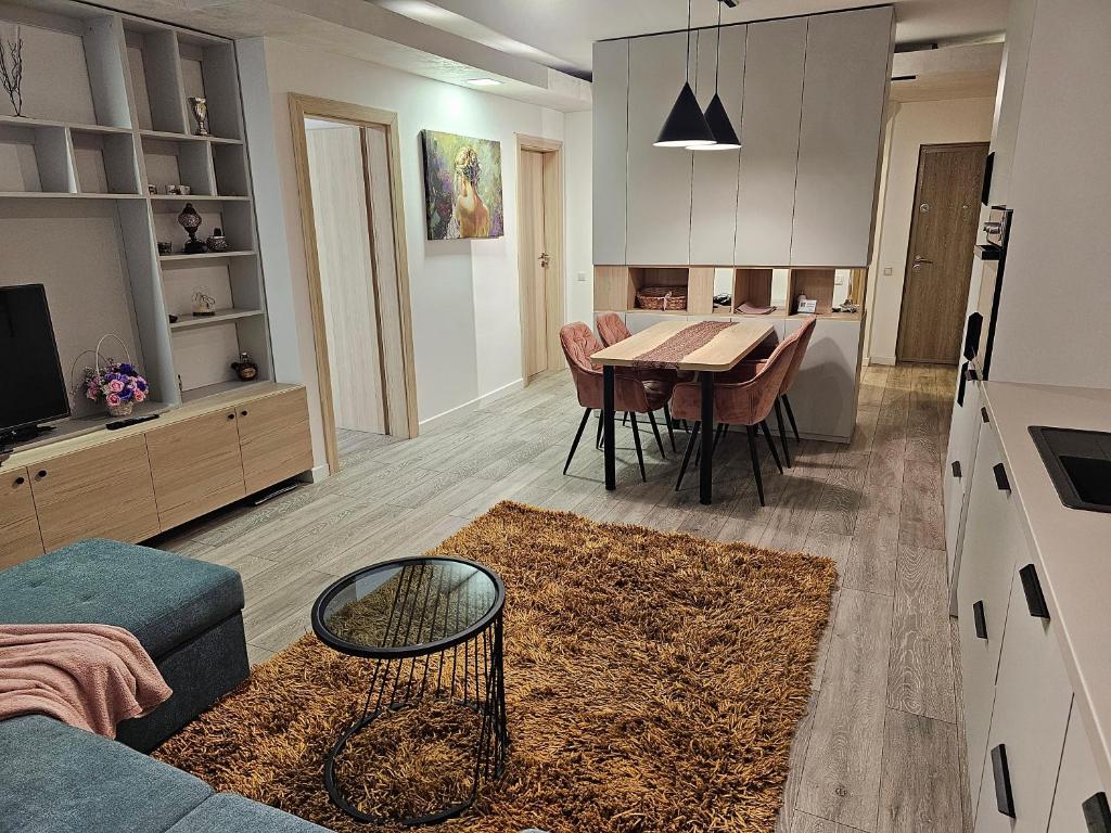 uma cozinha e sala de estar com uma mesa e um sofá em Nana Apartaments em Cluj-Napoca