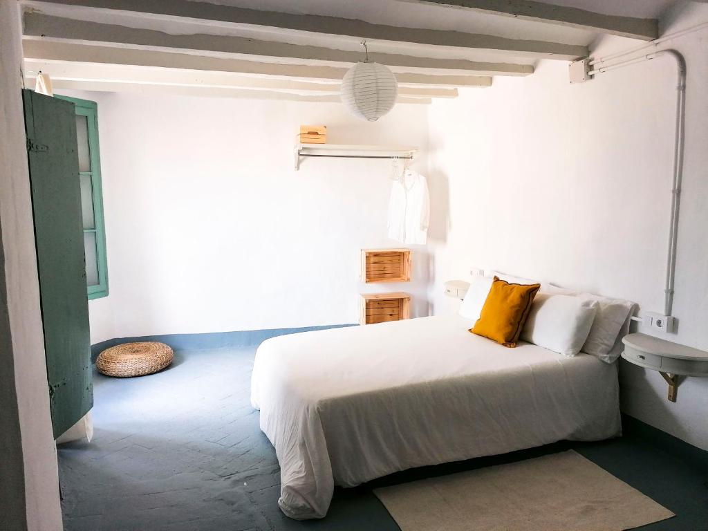 Vila Closa Juncosa في Juncosa: غرفة نوم بيضاء مع سرير ومغسلة