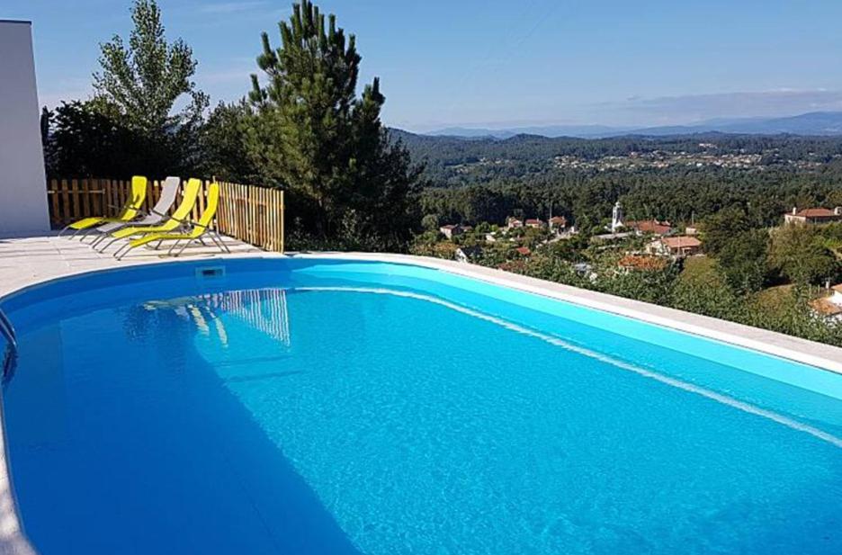 een zwembad met gele stoelen en uitzicht bij Verdvillage, Lda in Valença
