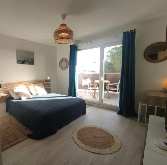une chambre avec un lit et une porte coulissante en verre dans l'établissement Studio 215 au Tennis Cap d'Agde, au Cap d'Agde