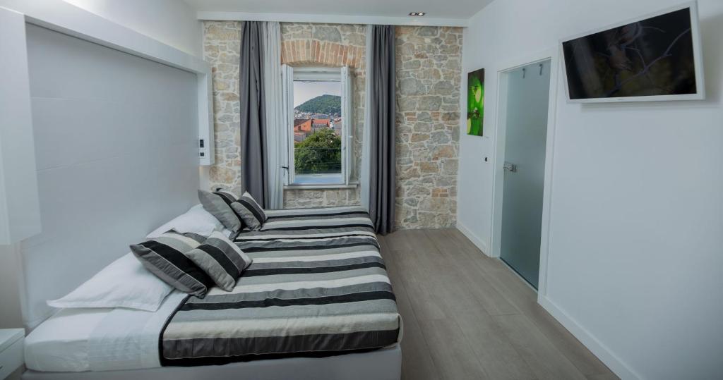 a bedroom with two beds in front of a window at A Heritage Split in Split