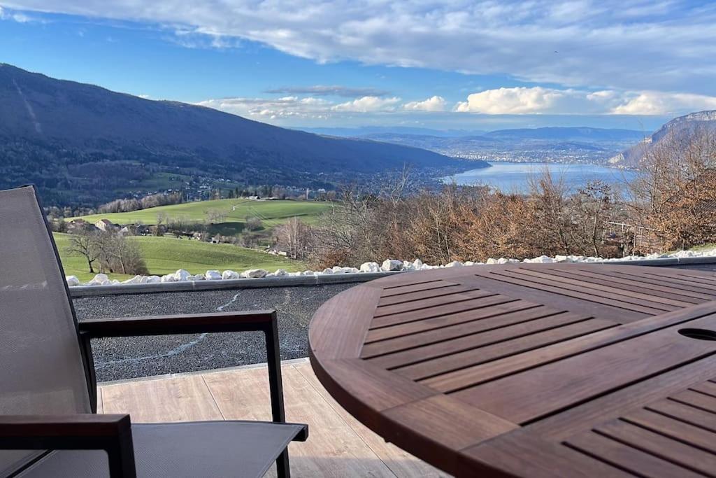 - une table en bois sur un balcon avec vue sur le lac dans l'établissement Magnifique Suite Takapuna 4/6p vue lac & montagne, à Saint-Eustache