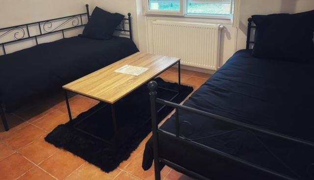 a room with two beds and a wooden table and a bed at Gite for you muguet in Neuvy-sur-Loire