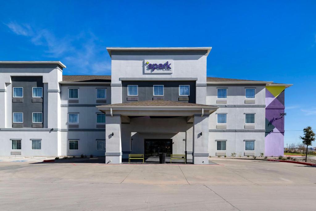 a large white building with a sign on it at Spark by Hilton Midland South in Midland