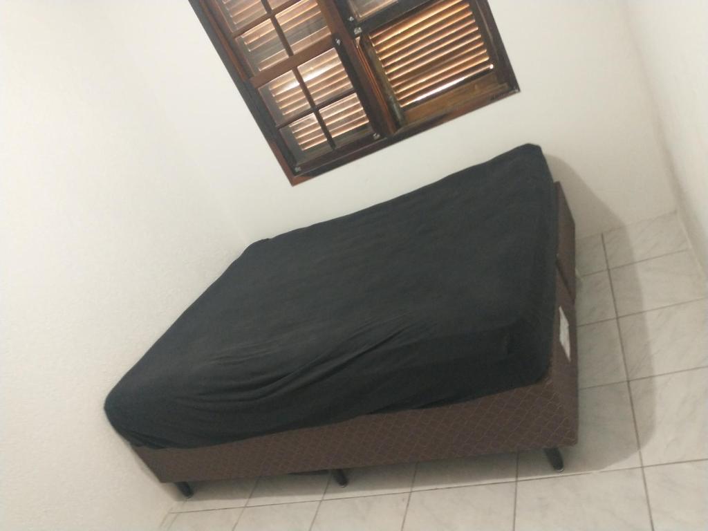 - un lit avec un drap noir dans une chambre dans l'établissement Casa de praia, à Florianópolis