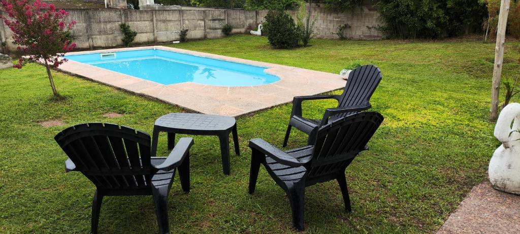 2 sillas y una mesa en un patio con piscina en Chalet Carlos Paz, en Villa Carlos Paz