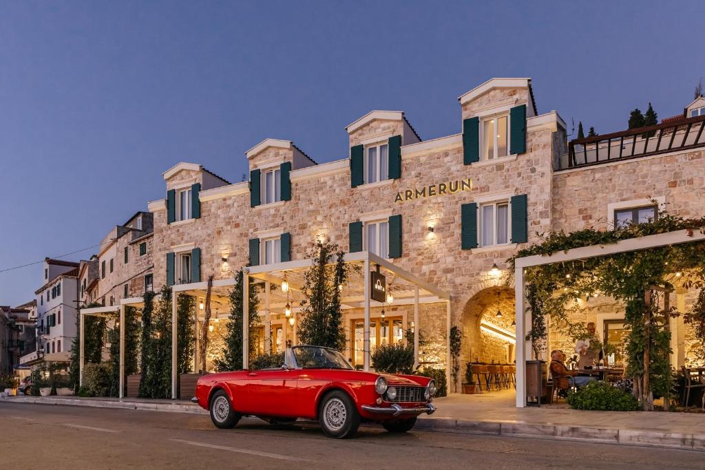 um carro vermelho estacionado em frente a um edifício em Armerun Heritage Hotel & Residences em Sibenik