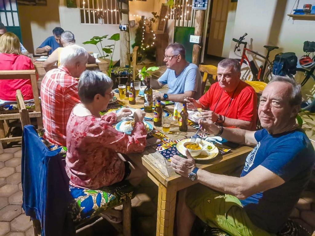 een groep mensen die aan een tafel eten bij The Secret Garden Hotel Moshi in Moshi
