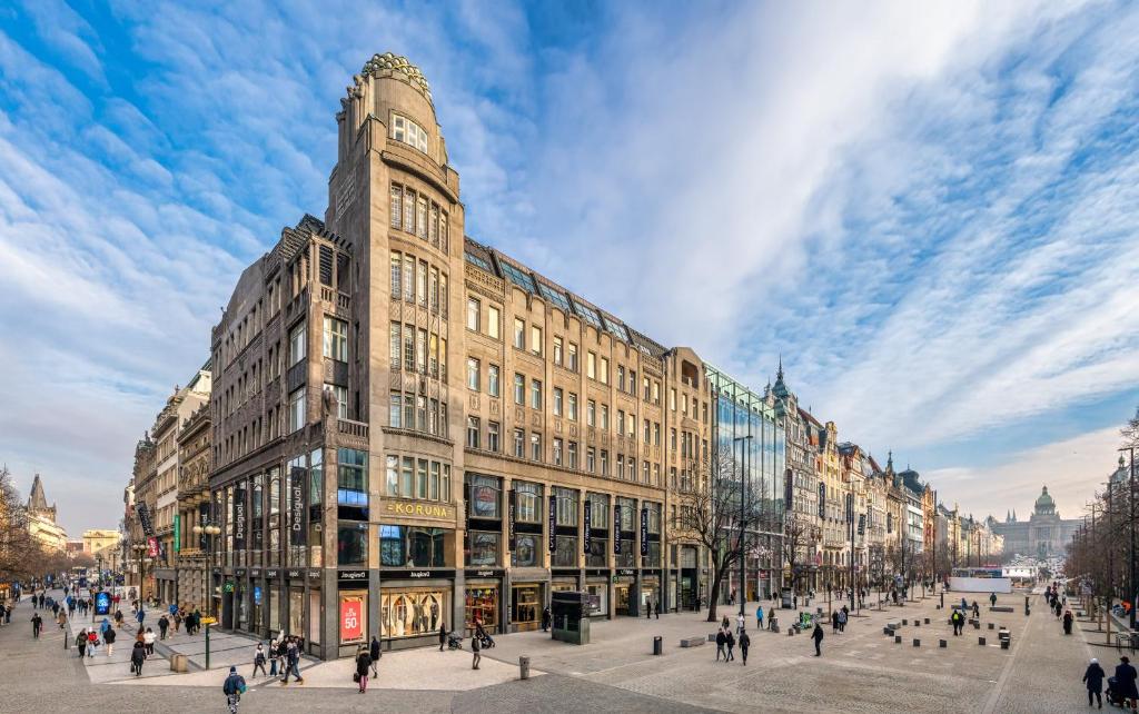 a large building with a clock tower on a city street at Crown Palace Apartments by Adrez in Prague