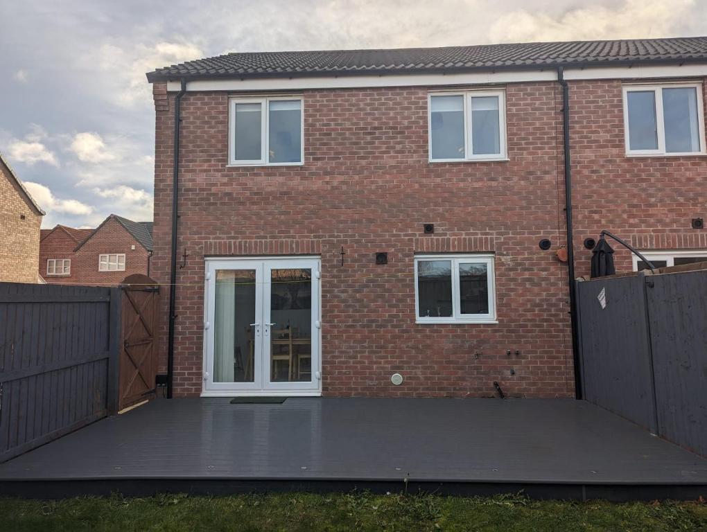 a brick house with a large patio in front of it at Freshen-up stays Doncaster in Bentley