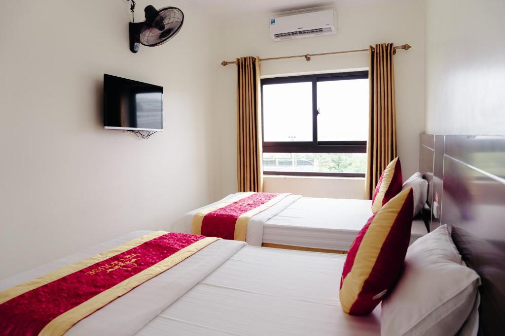 two beds in a room with a window at VIET HOUSE HẠ LONG HOTEL in Ha Long
