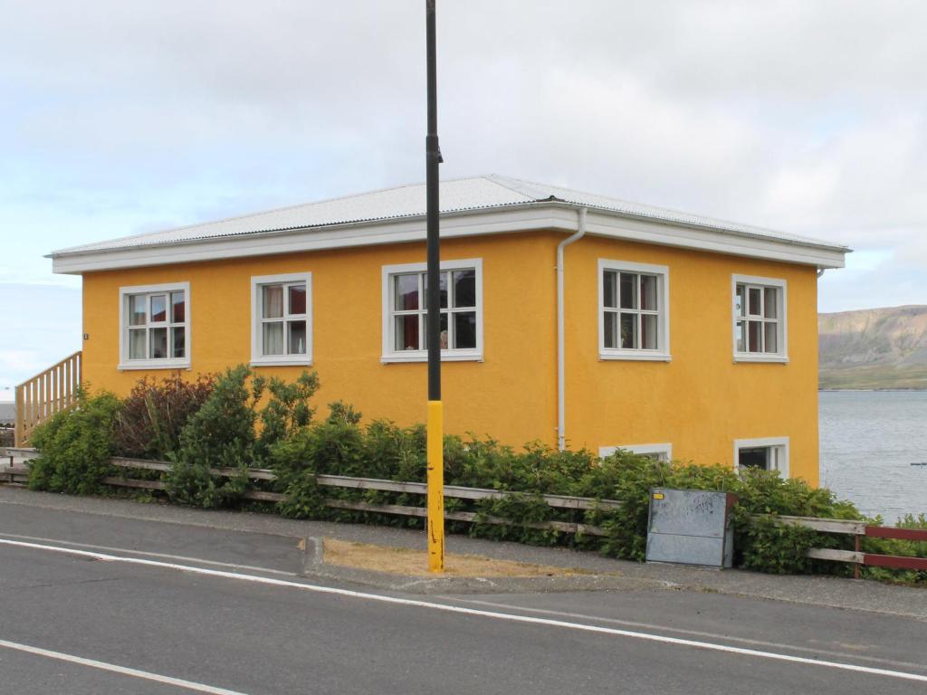 una casa amarilla al lado de una carretera en Bjarg Apartments, en Grundarfjordur