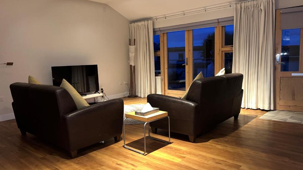 a living room with two chairs and a television at Bayview Cottage in Lamlash