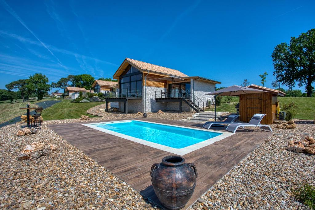 ein Haus mit einem Pool und einem Haus in der Unterkunft L'Orée du Bois du Domaine des Hauts de Rouquette in Eymet