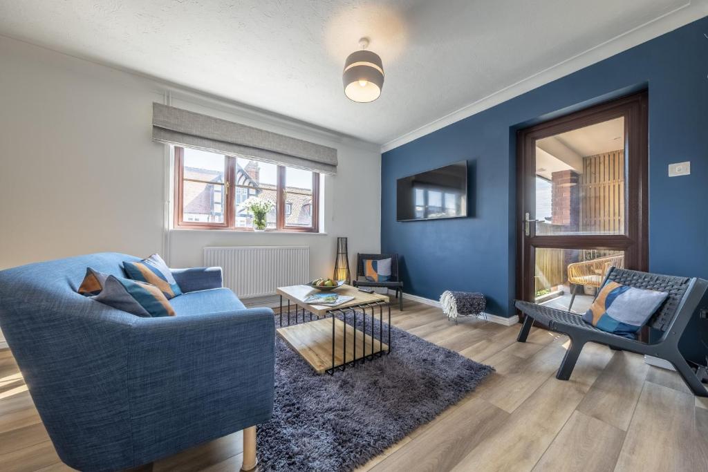 sala de estar con sofá azul y silla en The Pullman en Sheringham