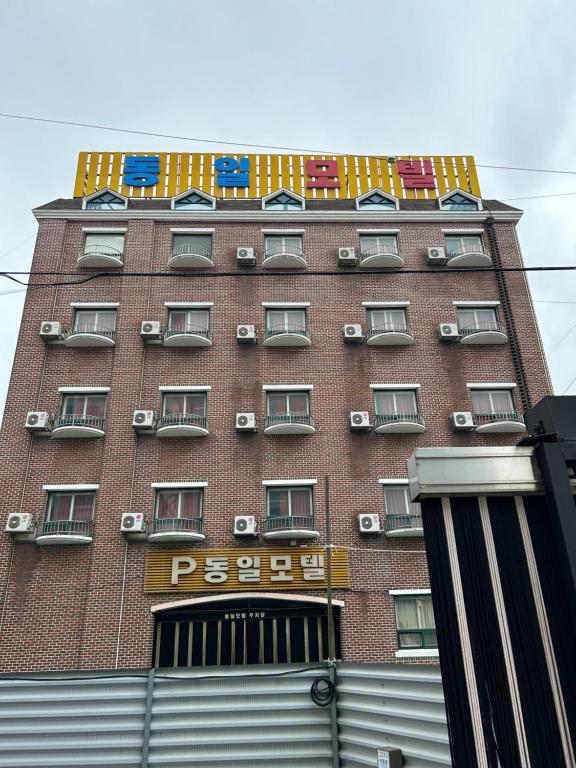 a tall red brick building with a sign on it at Dongil Motel in Mokpo