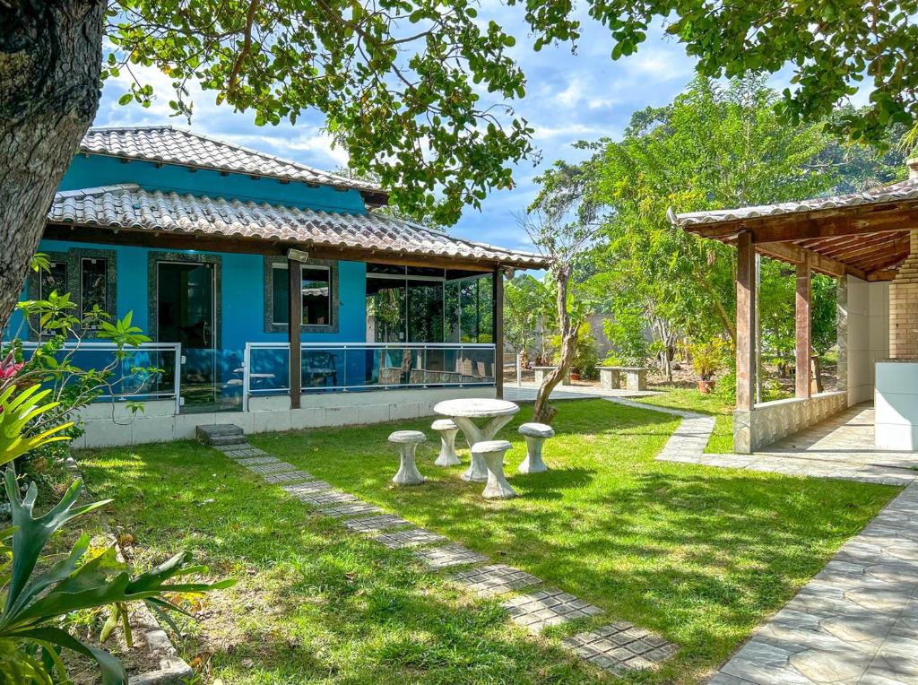 a blue house with a picnic table in the yard at Chácara com Wi-Fi em São Pedro da Aldeia - RJ in São Pedro da Aldeia