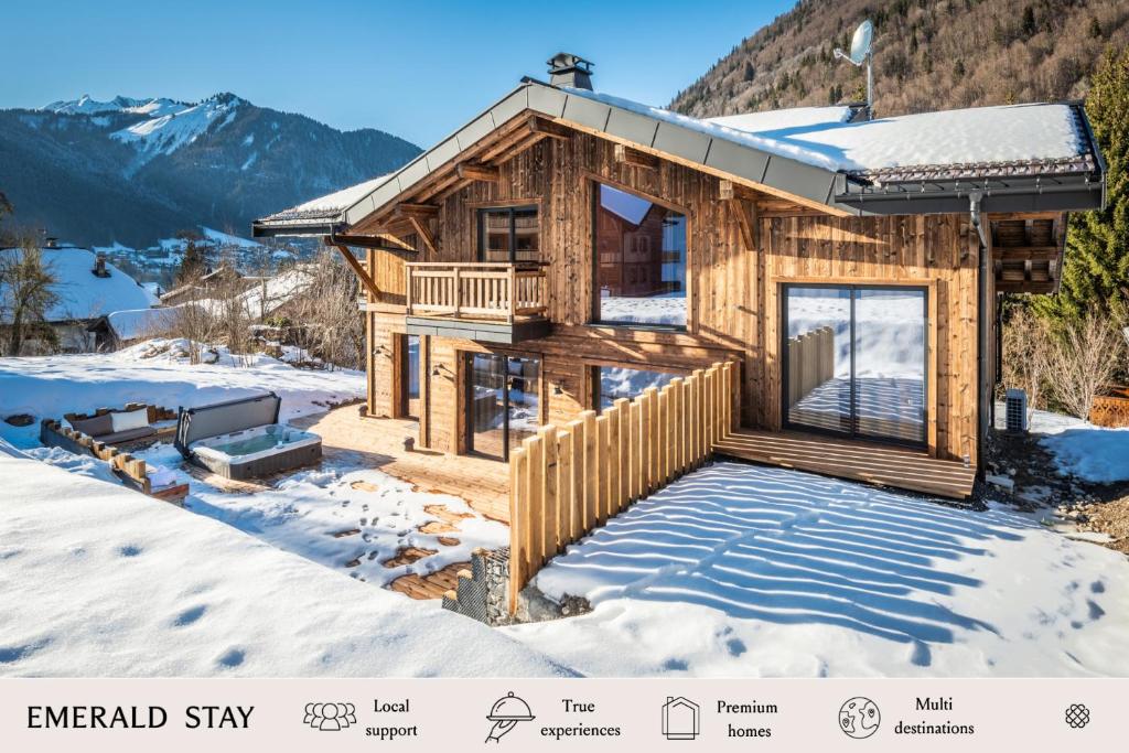 uma cabana de madeira na neve com um deque em Chalet Azobe Morzine - by EMERALD STAY em Montriond