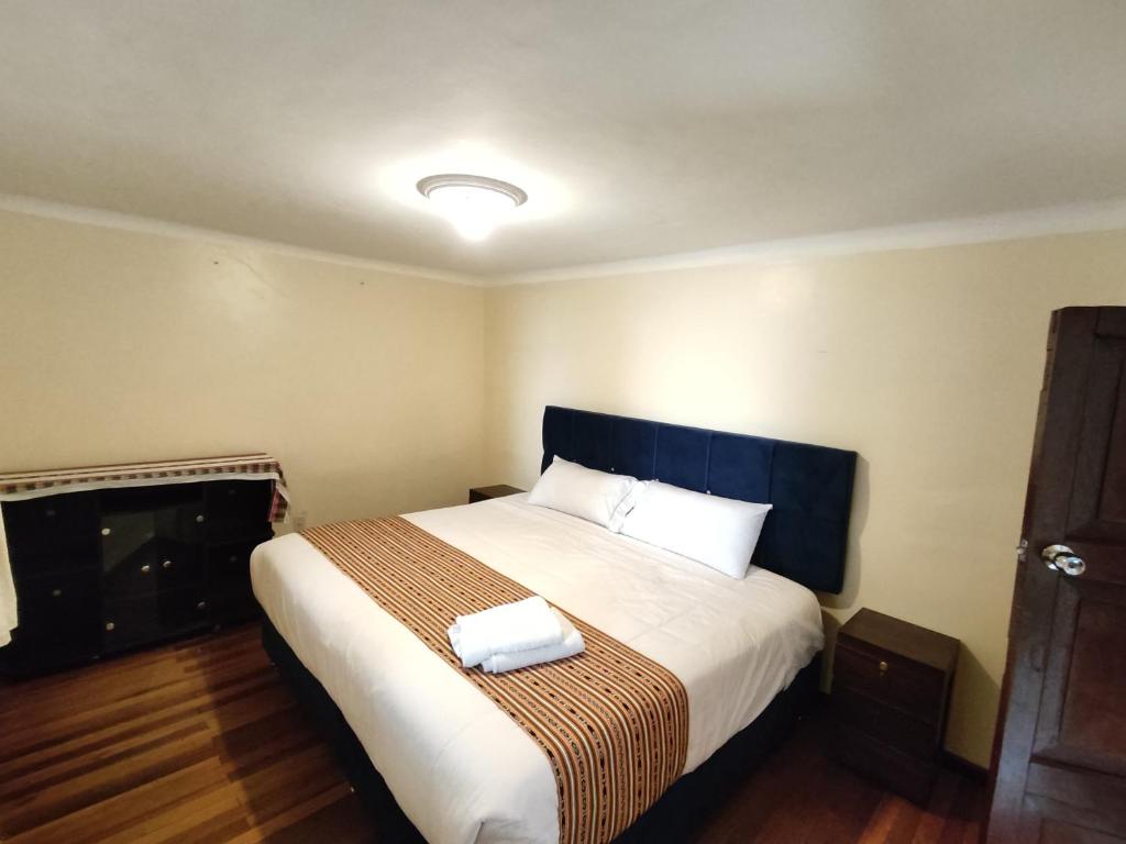 - une chambre avec un grand lit et des draps blancs dans l'établissement Qosqo Apartments 3, à Cusco