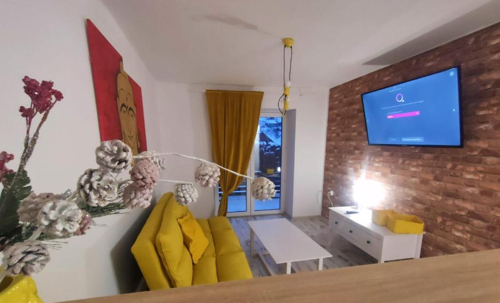 un soggiorno con sedie gialle e un muro di mattoni di Apartamenty na Maciejową a Rabka-Zdroj