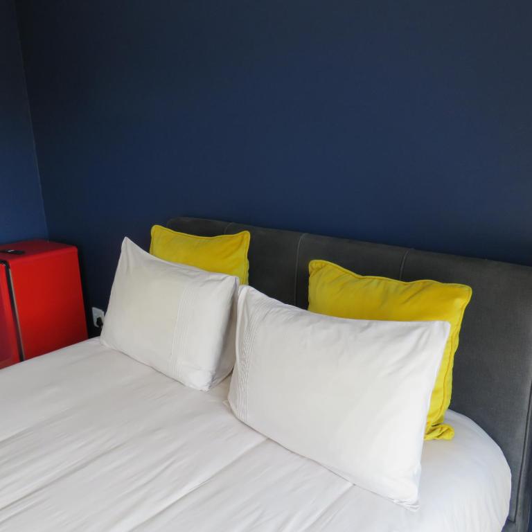 1 cama con 3 almohadas blancas y 2 almohadas amarillas en 43 Home apartment en Del Judor