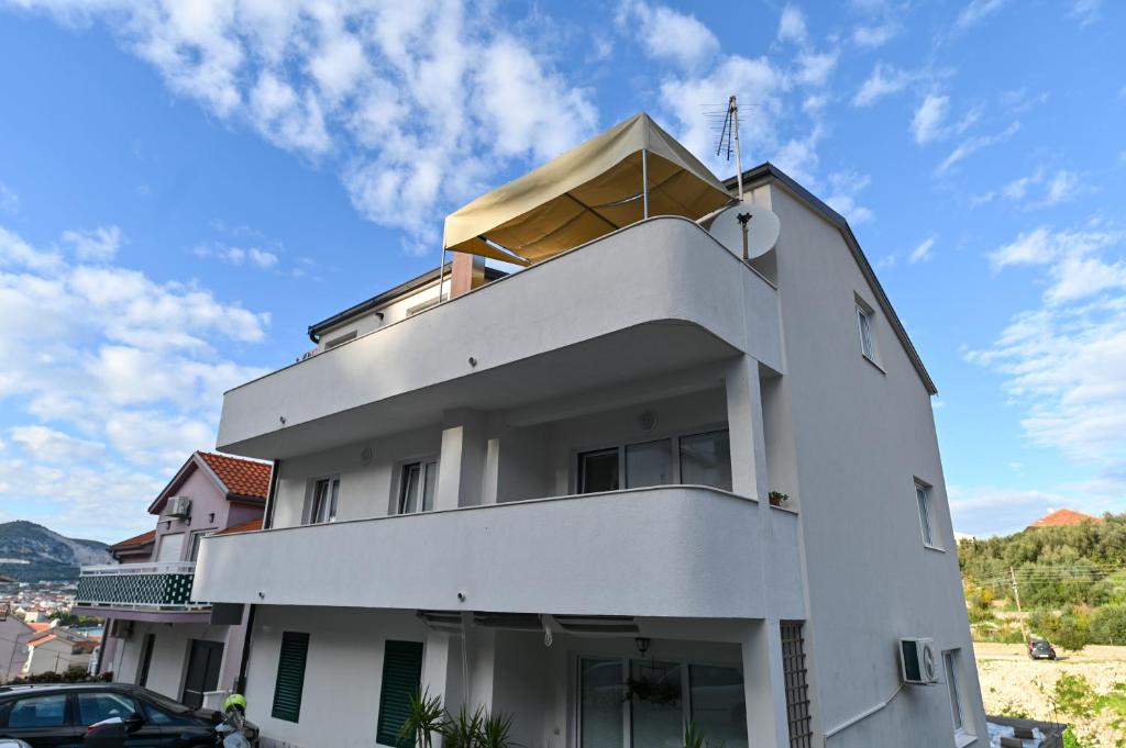 - un bâtiment blanc avec un balcon au-dessus dans l'établissement Apartman Mišura, à Trogir