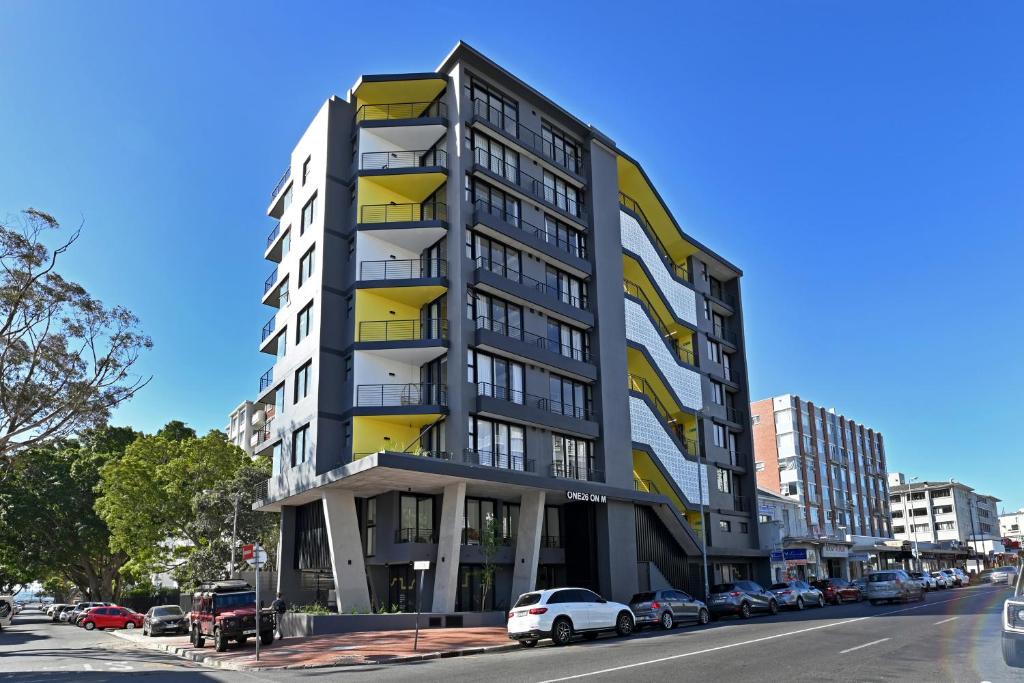 a tall building on a city street with parked cars at One26 On M Luxury serviced apartments - By Elevate in Cape Town