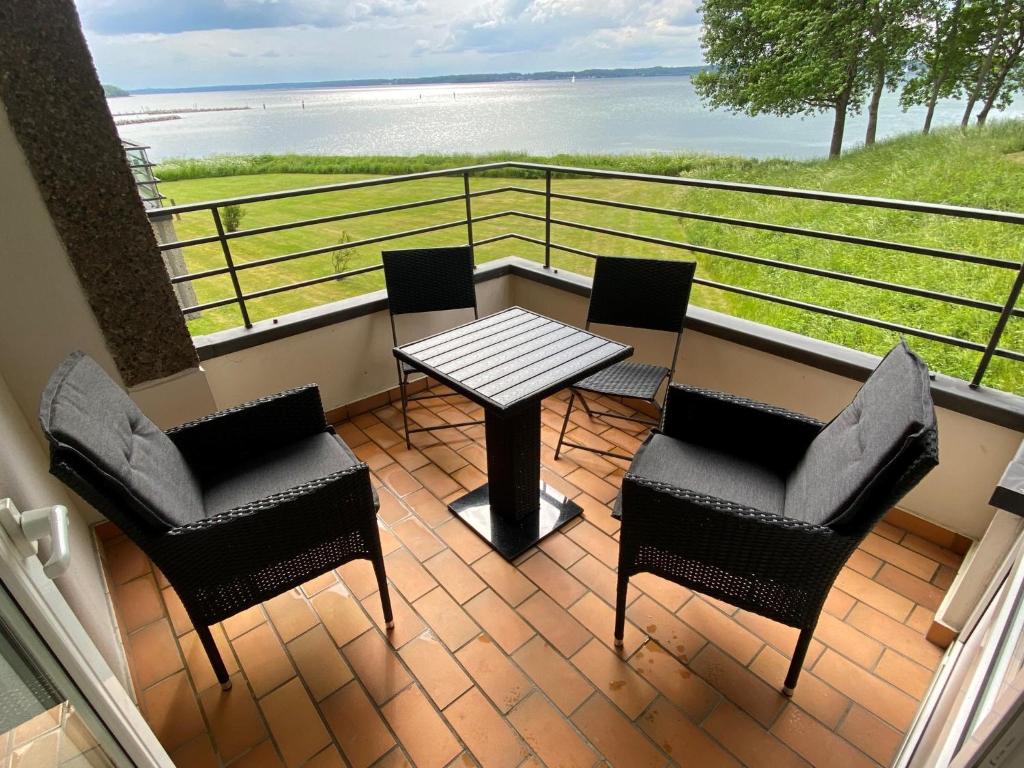 d'un balcon avec une table et des chaises donnant sur l'océan. dans l'établissement Ferienwohnung Am Leuchtturm, à Schausende