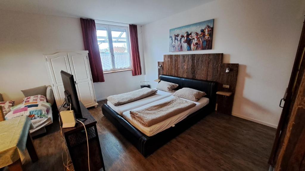 a bedroom with a bed with a wooden headboard at Hopfenalm in Ilmmünster