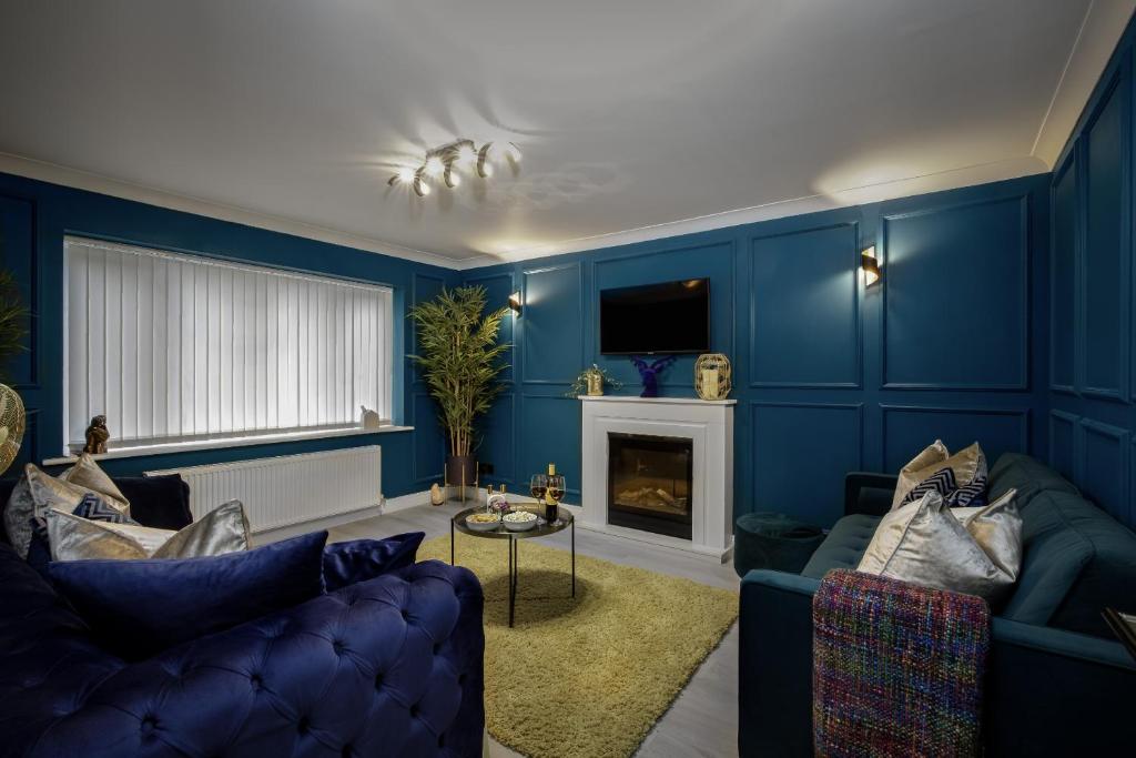 a blue living room with two blue couches and a fireplace at Belverdale by STAMP SA in Blackpool