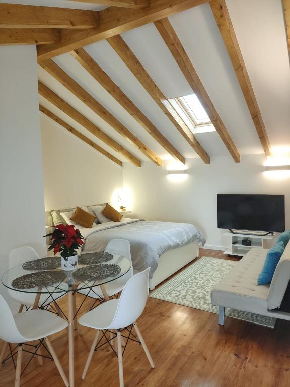 a bedroom with a bed and a table and chairs at Charm studio in Bombarral