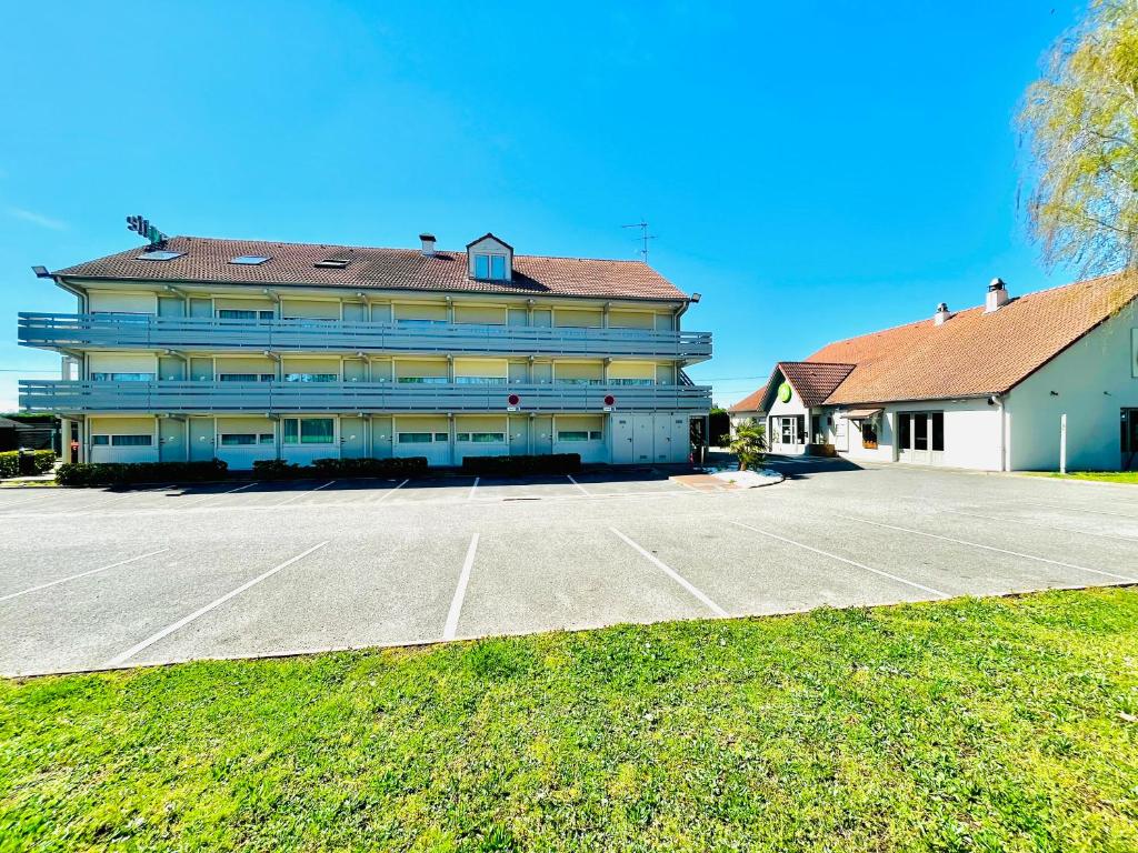 a large building with a parking lot in front of it at Campanile Montargis - Amilly in Amilly