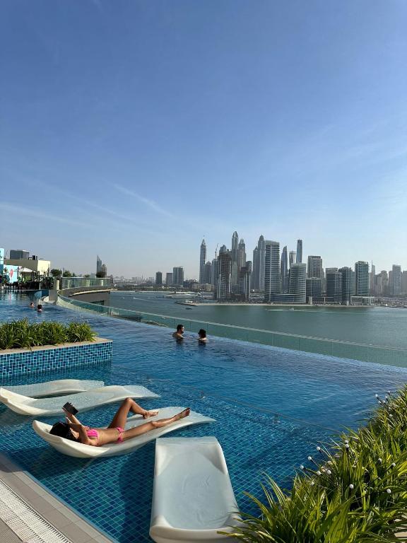 een vrouw op een bordje in een zwembad bij 7 Palm Jumeirah in Dubai