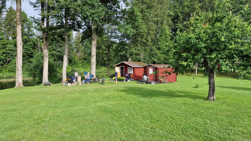 un grupo de personas en un parque con una cabaña en Jõeallika kämping, 