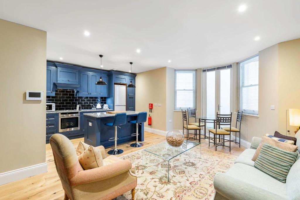 a kitchen and living room with blue cabinets at Colourful Studio Near Clapham Common! in London