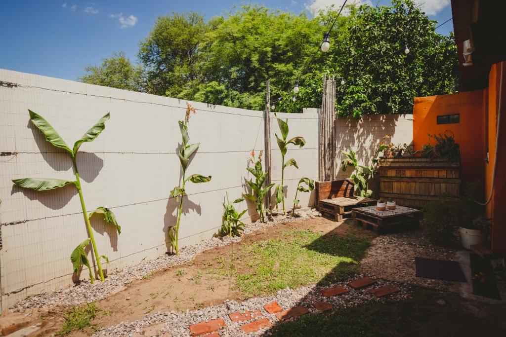 un patio trasero con una valla blanca y plantas en La Escondida en Córdoba