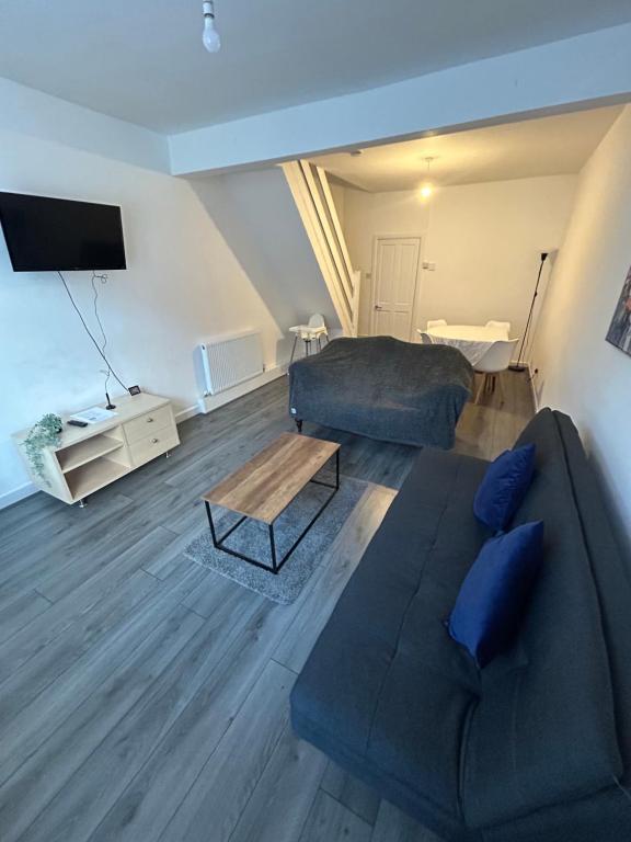 uma sala de estar com um sofá e uma televisão em Charming Liverpool Home em Liverpool