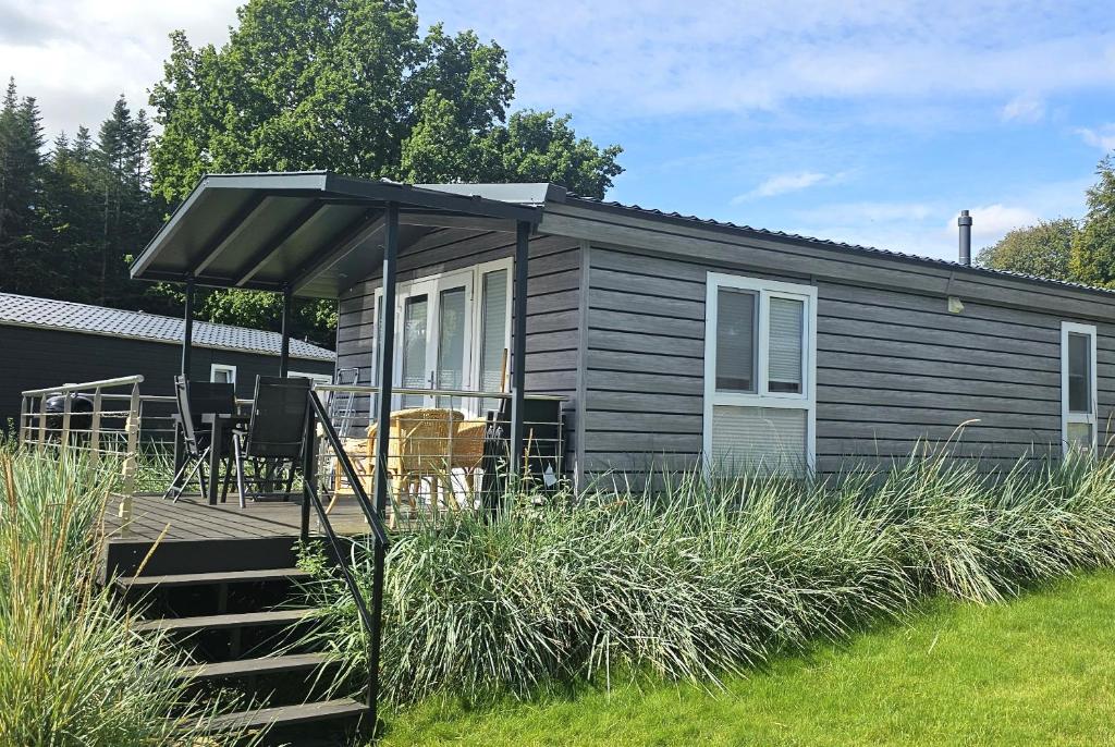 eine kleine Hütte mit einer Veranda und einer Terrasse in der Unterkunft Ferienhaus "Möwennest" in Scharbeutz