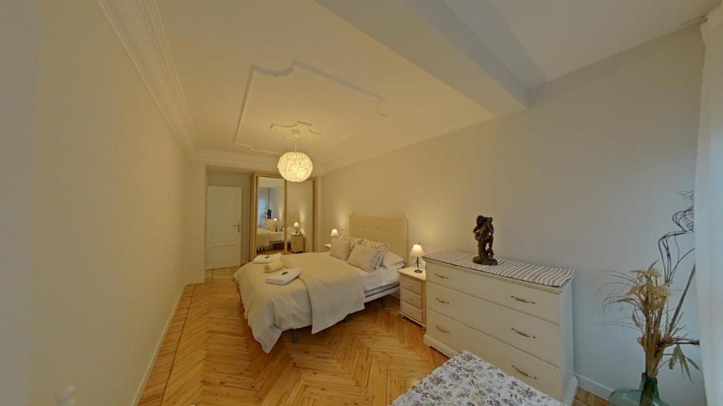 um quarto com uma cama, uma cómoda e um espelho em Casa Angela em Santoña