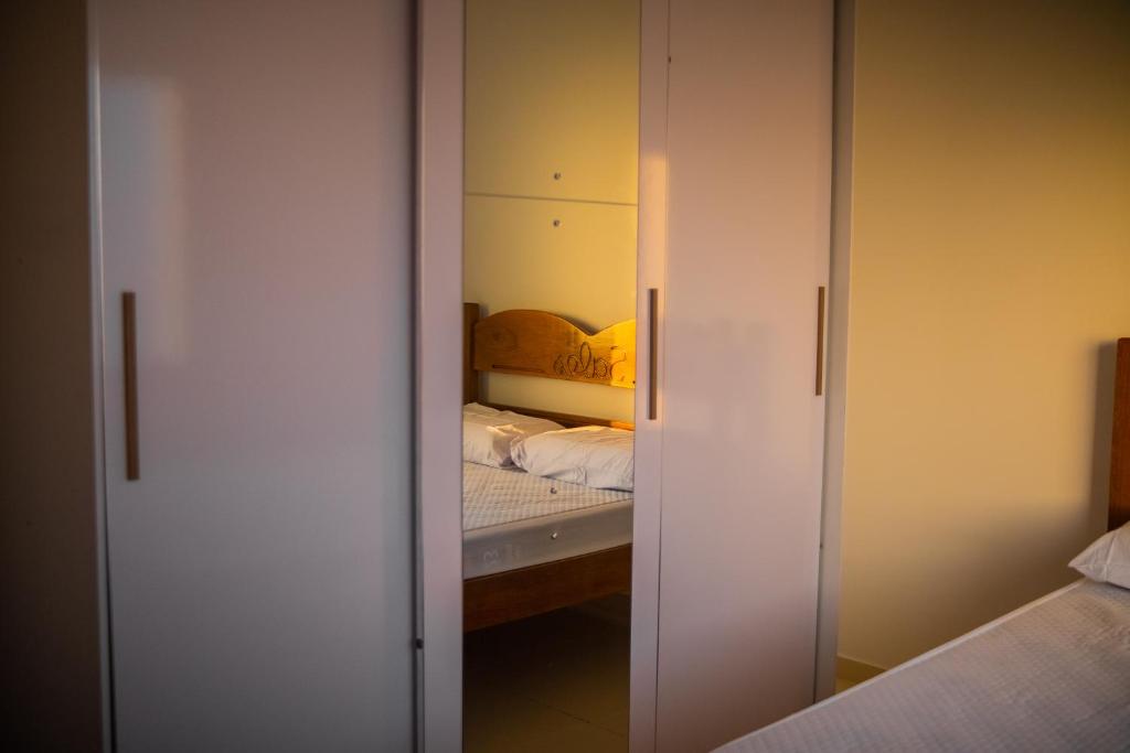 a bedroom with a closet with a mirror and a bed at Residencial Sales in Guaibim