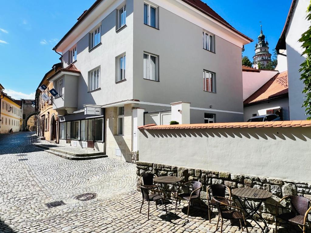 a cobblestone street with tables and chairs in front of a building at Pension MONO - Adults Only in Český Krumlov
