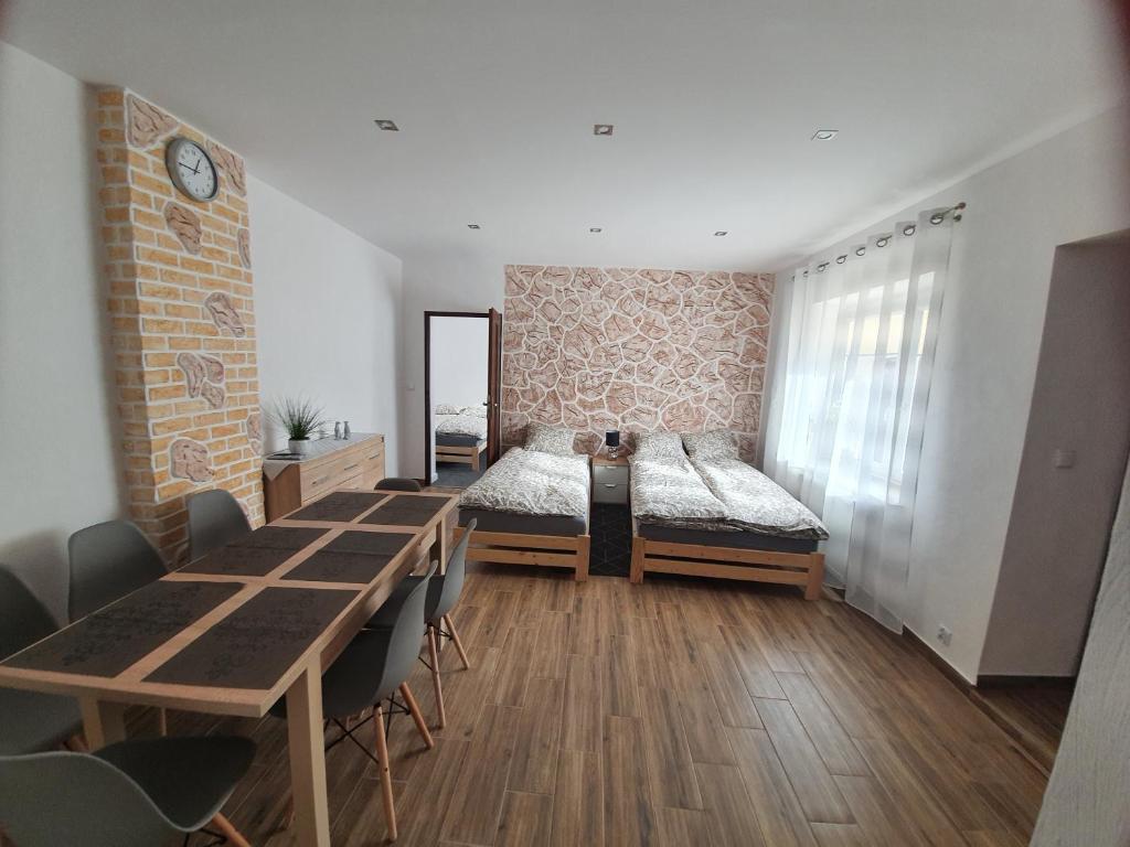 a room with two beds and a table and chairs at Apartament Mickiewicza in Stronie Śląskie