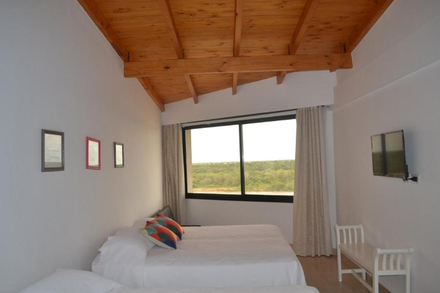 a bedroom with two beds and a large window at Costanera Goya Apart & Hotel in Goya