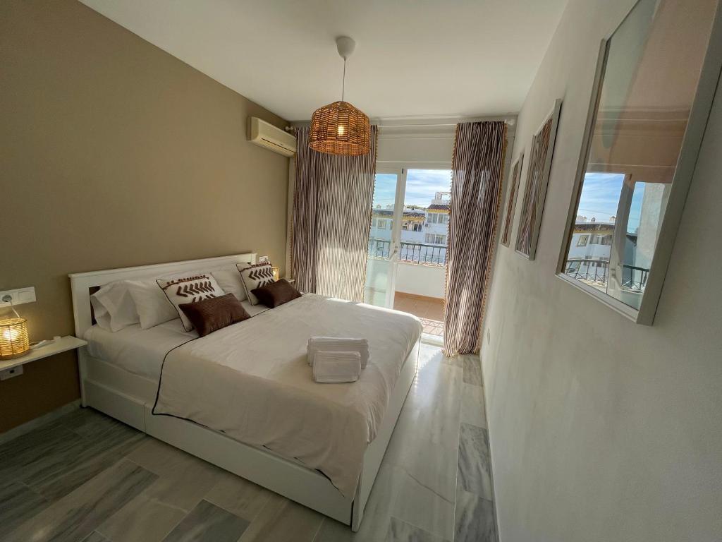 ein Schlafzimmer mit einem Bett und einem großen Fenster in der Unterkunft Cozy apartment in Costa del Sol in Mijas Costa