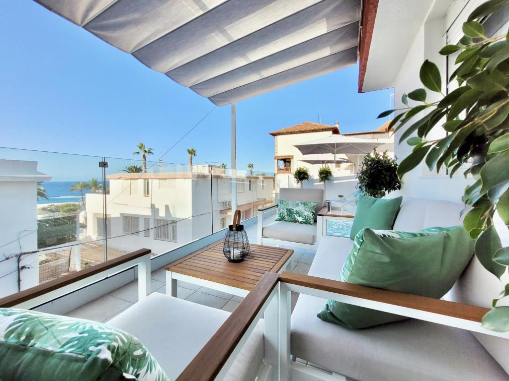 a balcony with white chairs and a wooden table at Attic 10 by Grupo Compostelana in Puerto de la Cruz