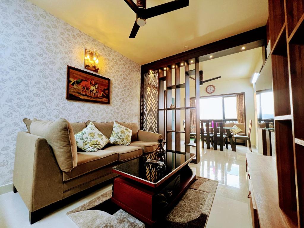 a living room with a couch and a table at Chic 2BR Haven in the midst of greenery. in Mangalore