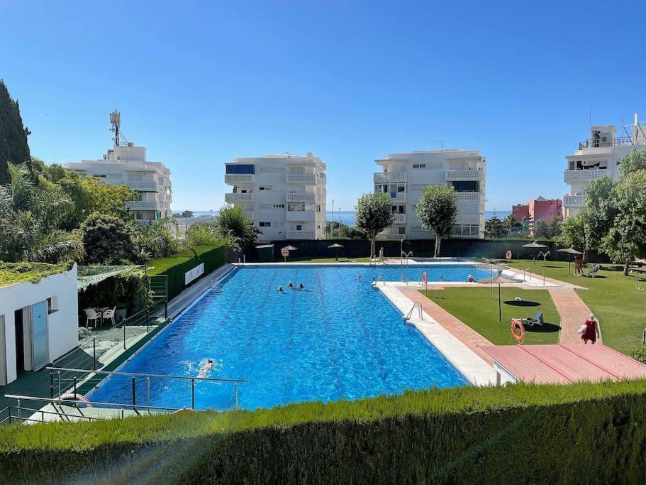 a large swimming pool with people in a city at Soleares Apartment - Close to the Beach! in Estepona