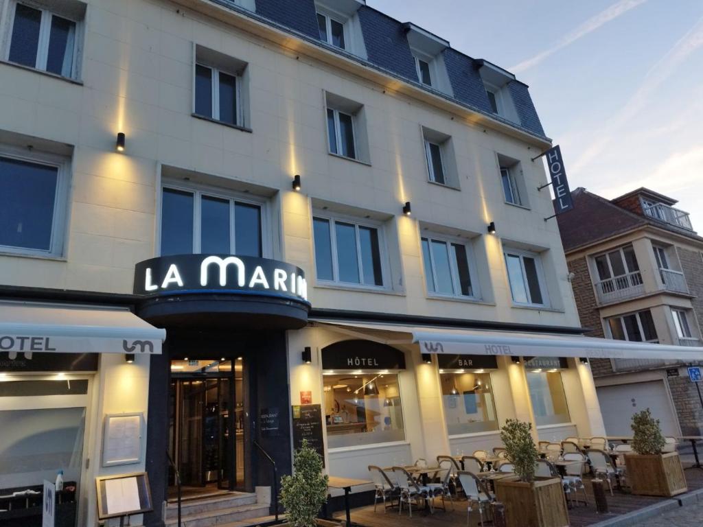 a large white building with a sign that reads la marriott at Le Grand Hôtel de la Marine in Port-en-Bessin-Huppain