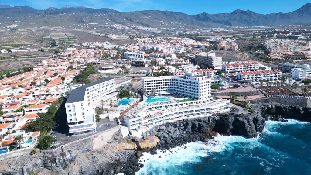 een luchtzicht op een resort op een klif naast de oceaan bij Pearly Grey Ocean Club Apartments & Suites in Callao Salvaje