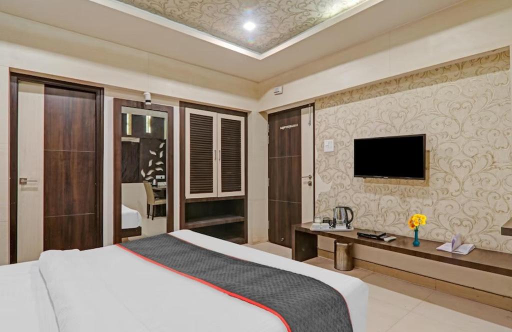 ein Schlafzimmer mit einem Bett und einem TV an der Wand in der Unterkunft Hotel Tirupati Galaxy in Kānpur
